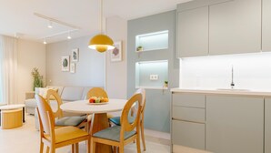 A modern kitchen with a round dining table, wooden chairs, and a pendant light. - Apartment 2 bedroom | ground floor| mountain view (La Caleta)