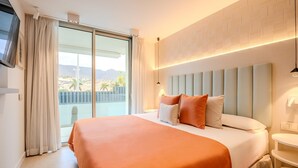 A hotel room with a large bed, a view of the outdoors, and a modern design.