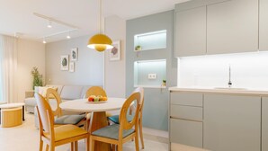 Une cuisine moderne avec une table de salle à manger ronde, des chaises en bois et un luminaire suspendu.