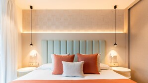 A modern hotel room with a large bed, two bedside tables, and a headboard with integrated lighting. - Apartment 2 bedroom | ground floor| mountain view (La Caleta)