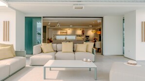 A modern living room with a sofa, a coffee table, and a dining area with chairs.