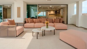 Ein modernes Wohnzimmer mit einer Couch, zwei Couchtischen und einem Korbstuhl.