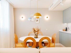A modern dining area with a round table, wooden chairs, and pendant lighting. - Apartment 3 bedroom | ground floor| mountain view (La Caleta)
