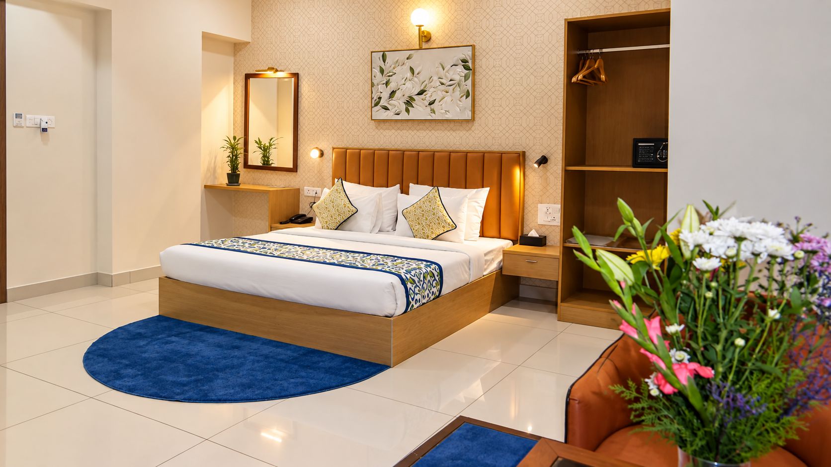 Een moderne hotelkamer met een groot bed, nachtkastjes, een kledingkast en een decoratief wandobject.