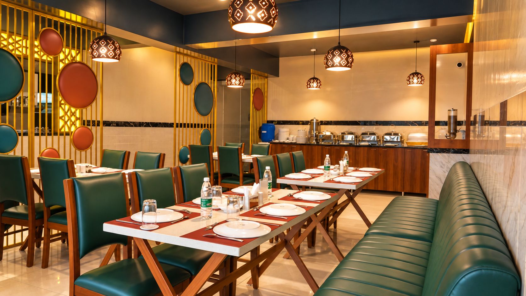 Um restaurante com uma mesa de jantar comprida preparada para vários convidados, rodeado por cadeiras estofadas verdes.