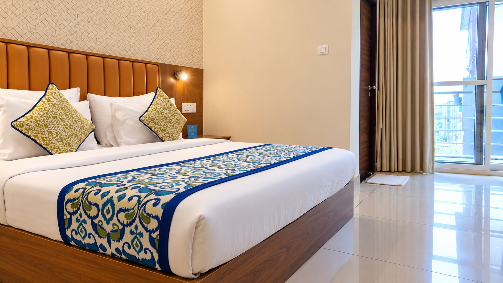 Una camera d'hotel con un letto grande, una testiera in legno e vista sulla città dalla finestra.