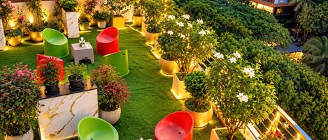 An outdoor seating area with potted plants and chairs.