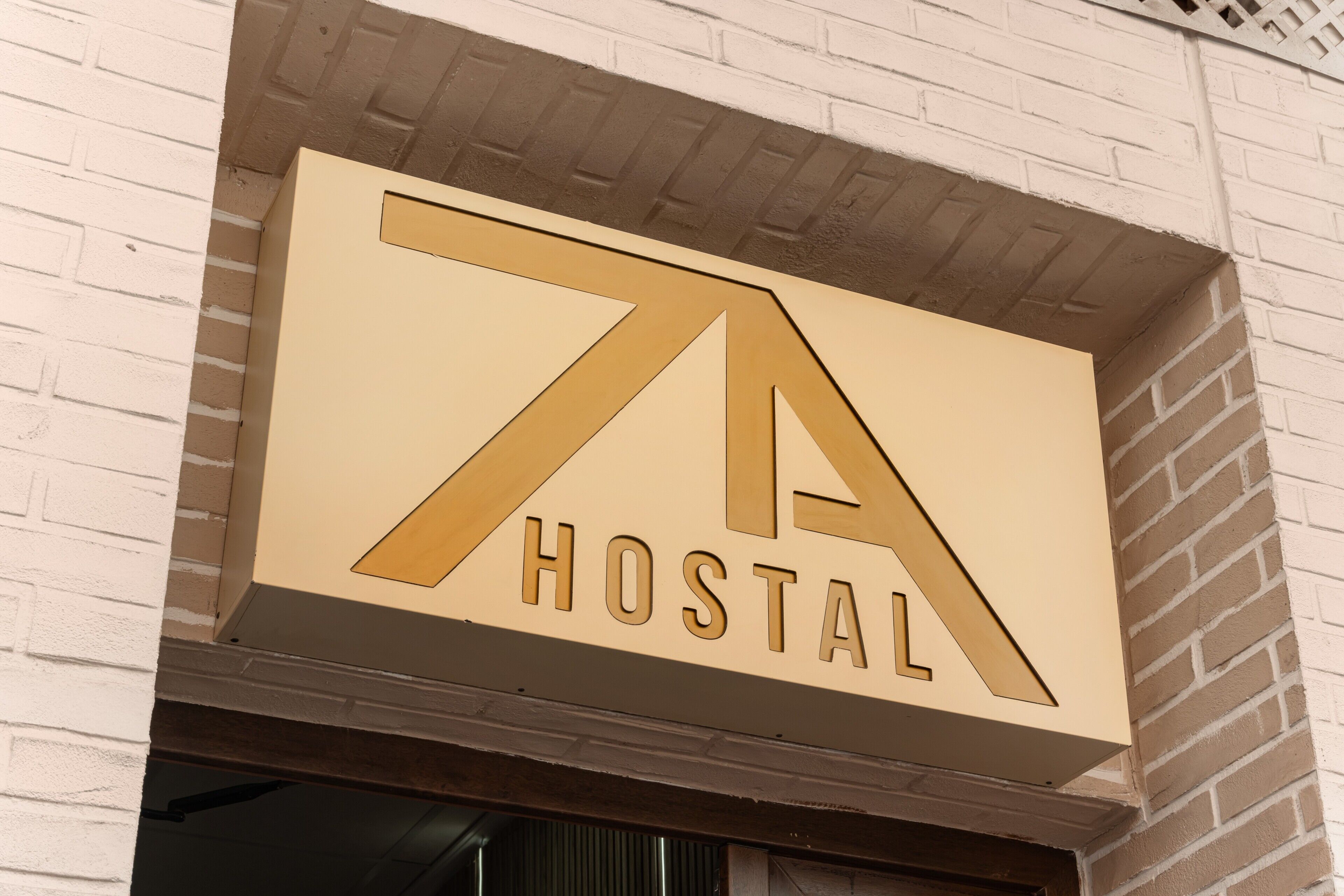 A sign with the word 'HOSTAL' on a building facade.