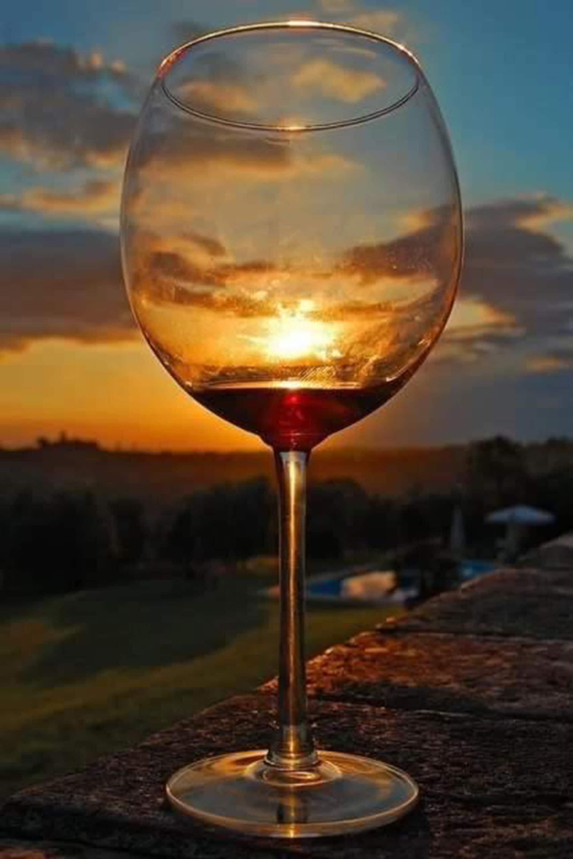Una copa de vino con vista al atardecer.