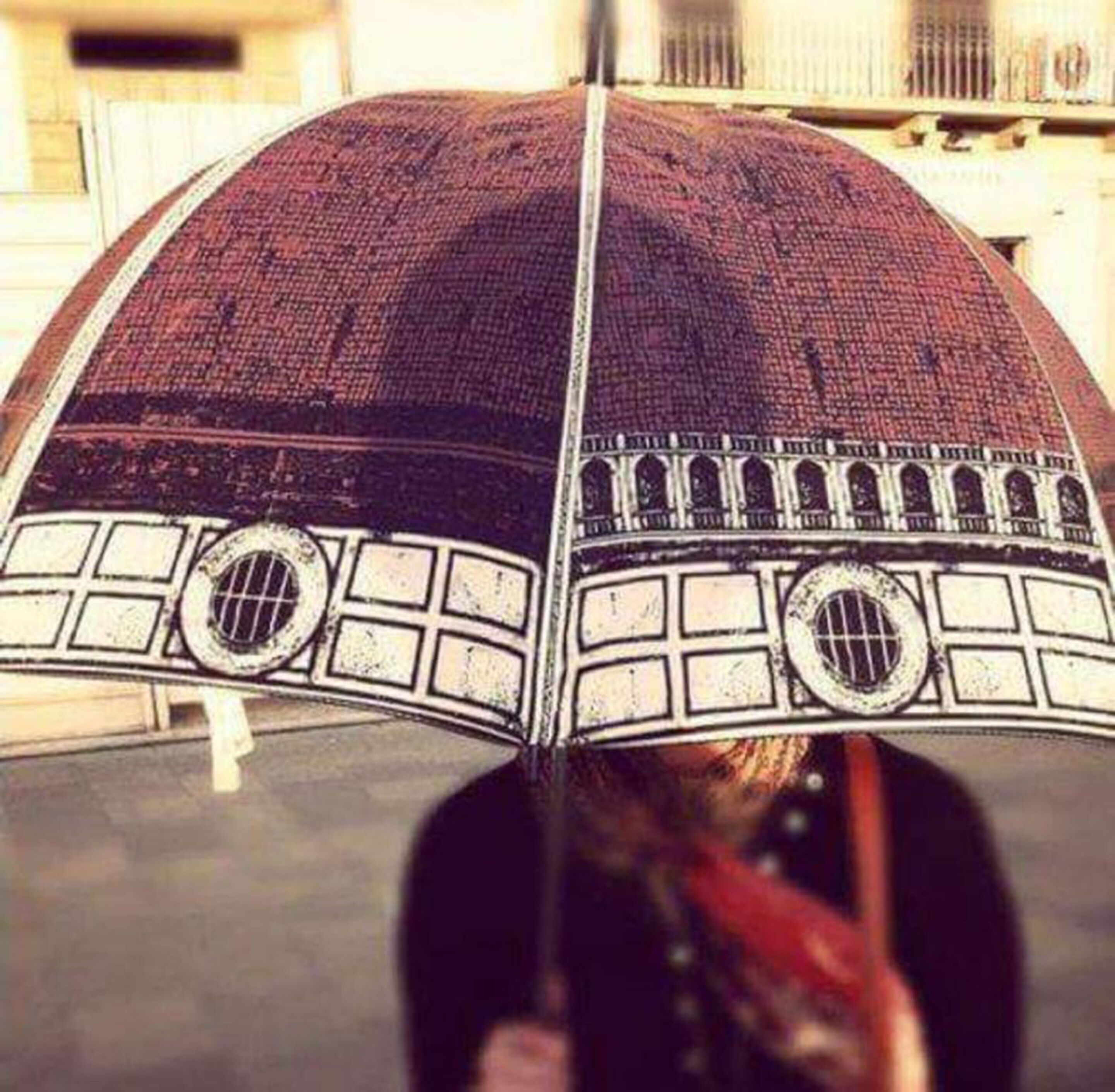 Uma pessoa segurando um guarda-chuva com um design arquitetônico detalhado.
