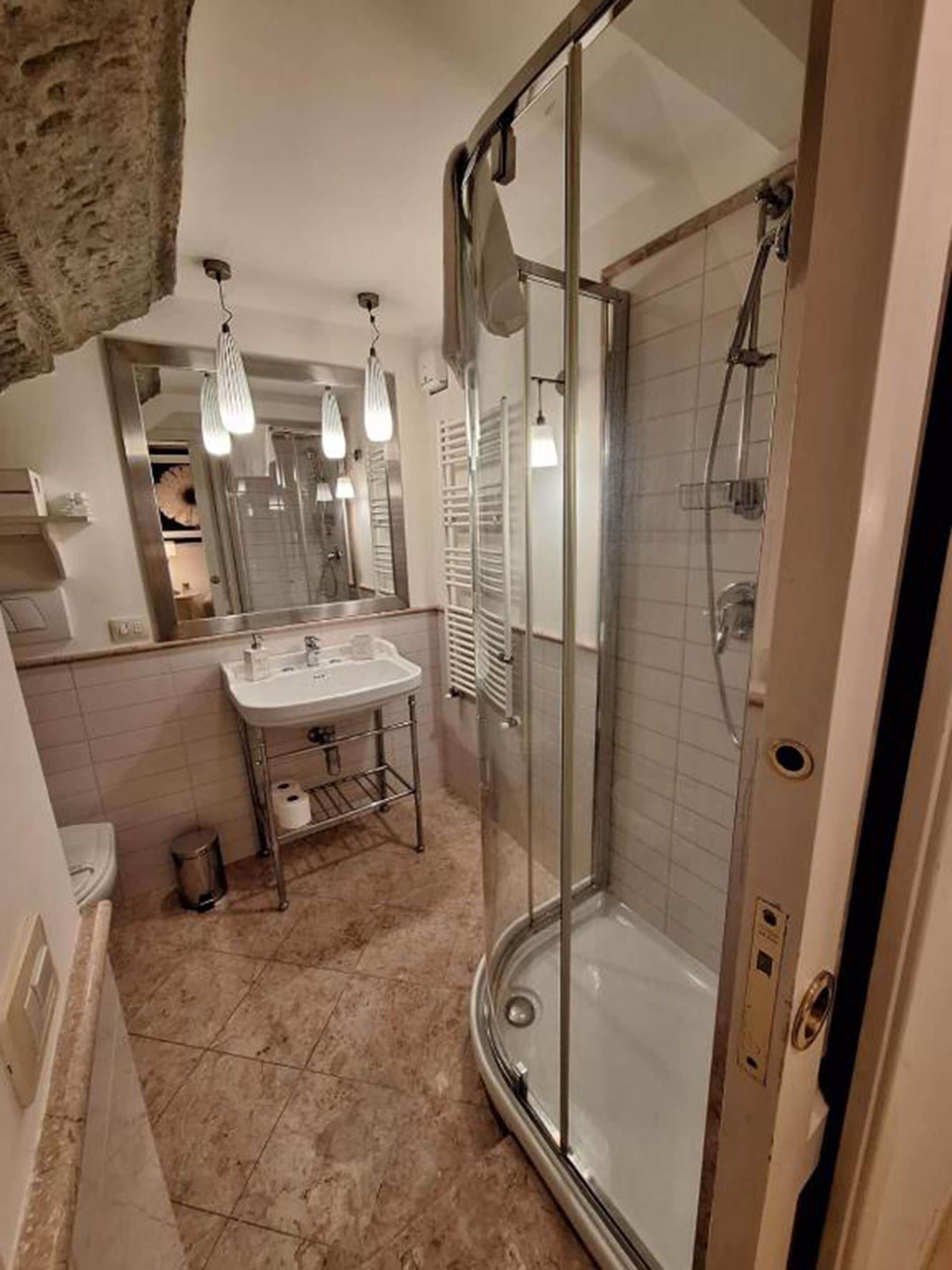 Une salle de bain moderne avec une douche à parois de verre, un meuble-lavabo et un miroir au-dessus du lavabo.