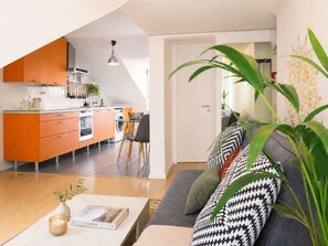 A modern apartment with a kitchen, dining area, and living room.