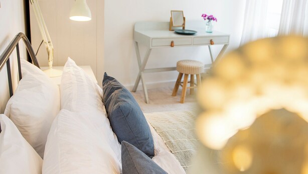 A bedroom with a bed, a desk, a stool, and a lamp. - Cornish Cottage - Truro City Centre (Truro)