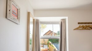 A room with a large window, a wooden door, and a framed picture on the wall. - Cornish Cottage - Truro City Centre (Truro)