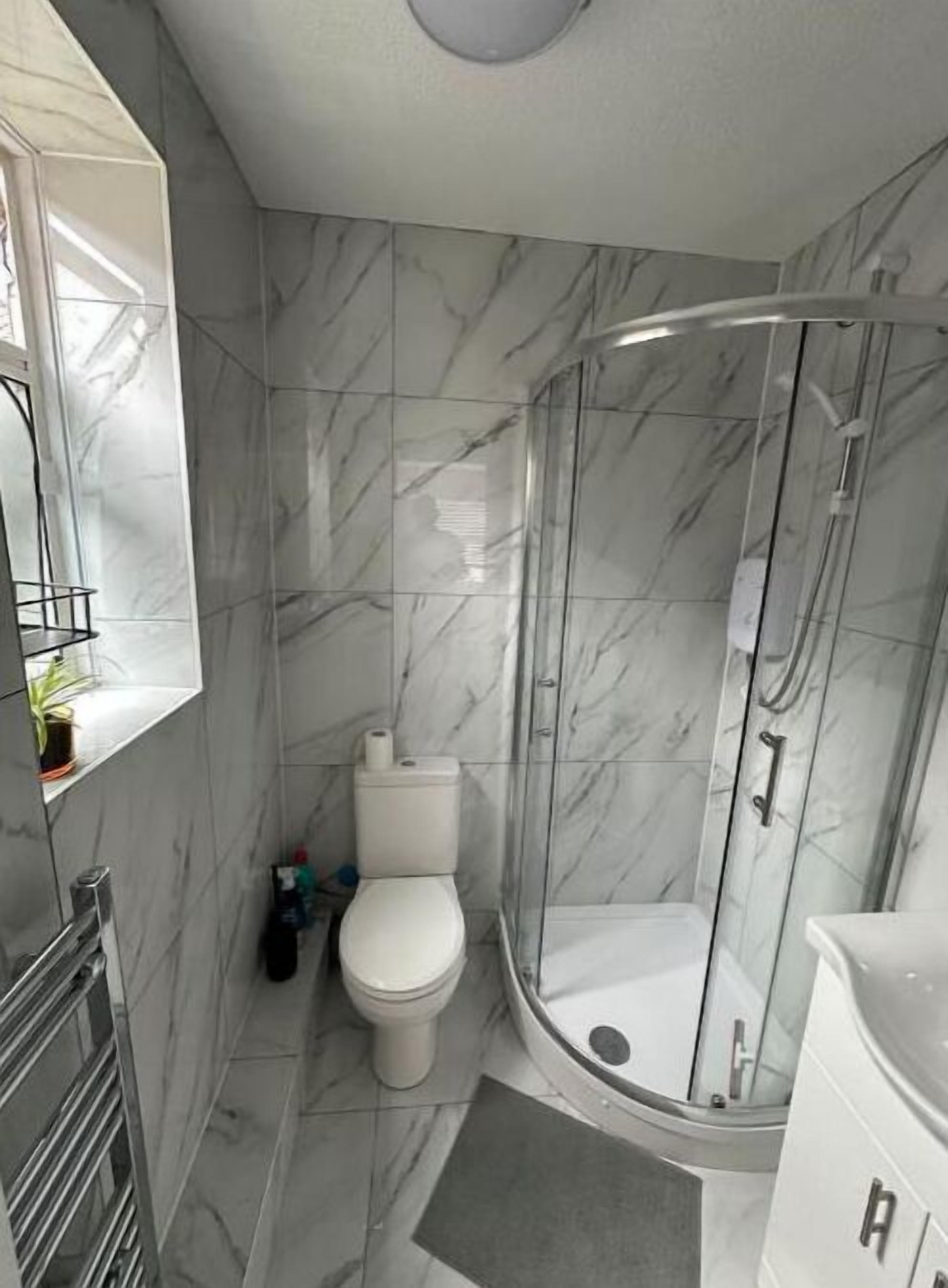 Een douche, handdoeken, zeep, toiletpapier