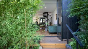 A modern interior with a staircase leading to a living area, surrounded by lush greenery. - UNIQUE- Boutique Designer - The Barn Paddington (Sydney)