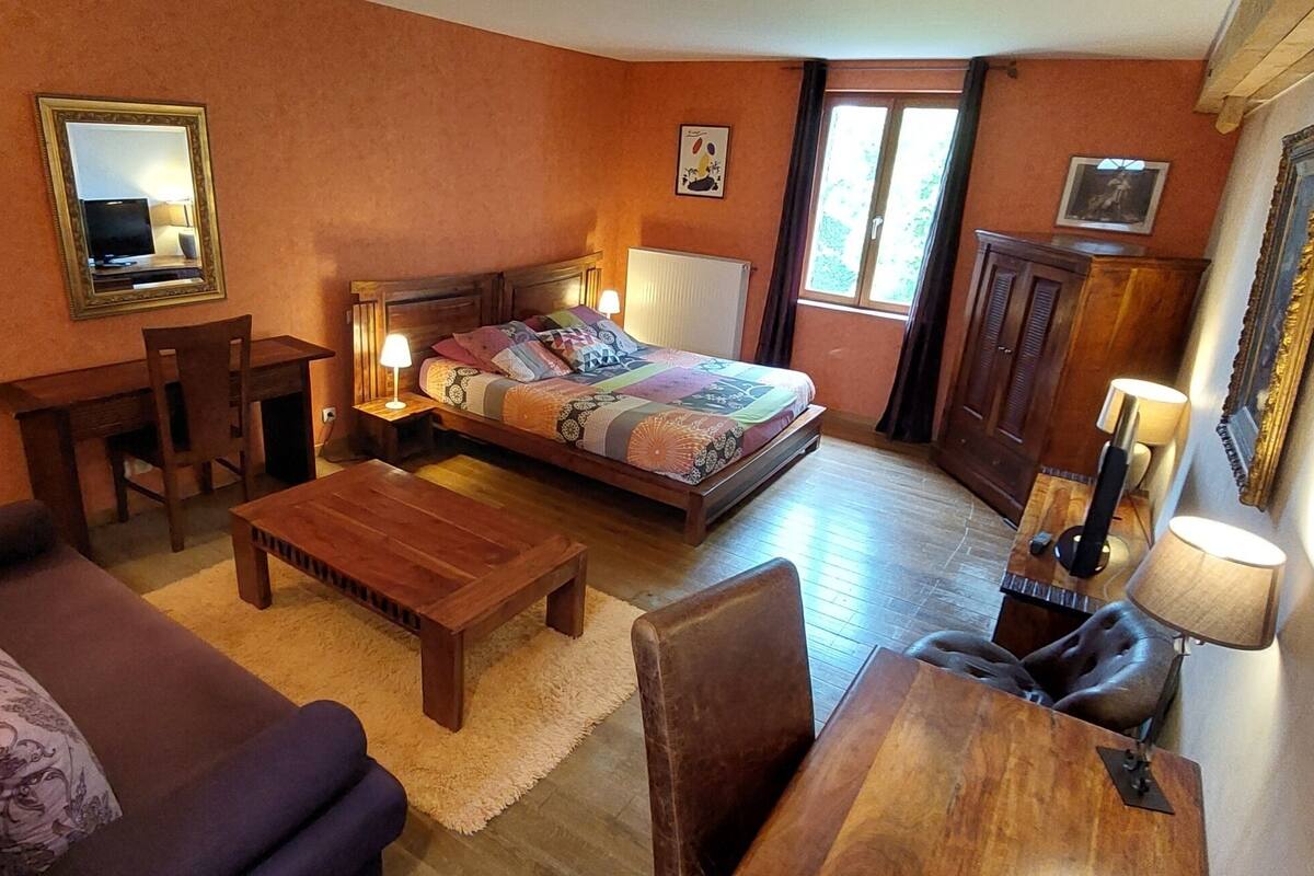 Une pièce confortable avec un lit, un bureau, une chaise, un canapé et une lampe.