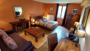 Une pièce confortable avec un lit, un bureau, une chaise, un canapé et une lampe.