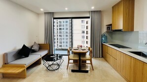 Un appartement moderne comprenant un coin repas, une cuisine et un canapé avec des coussins.