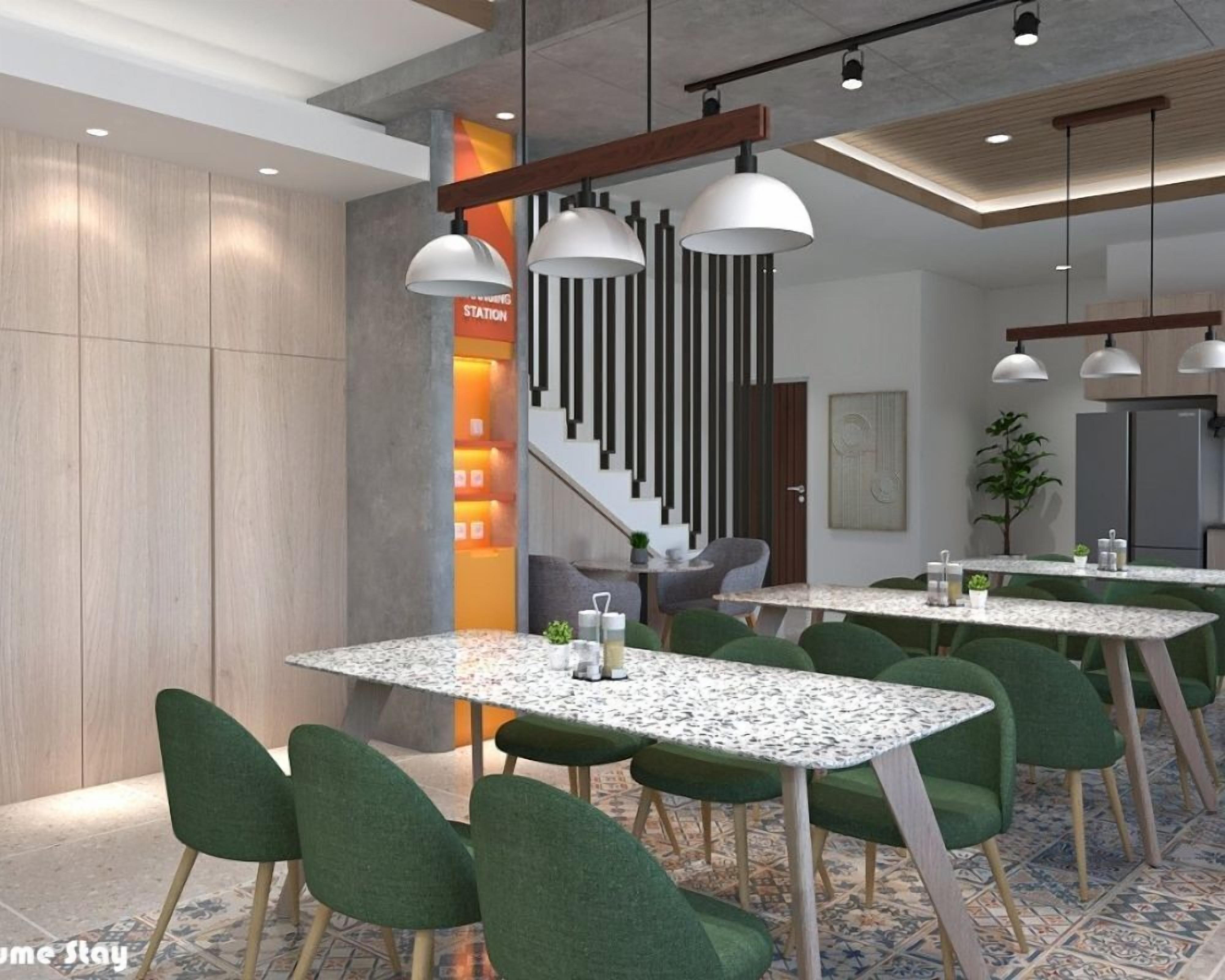 Un comedor moderno con varias mesas y sillas, una escalera e iluminación colgante.