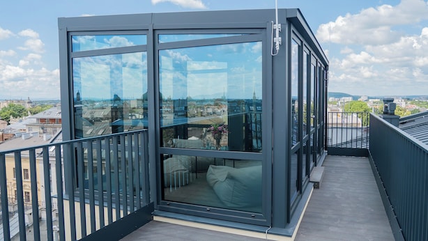 A modern glass-enclosed balcony with a view of the cityscape. - Długa 17 Residence (Kraków)