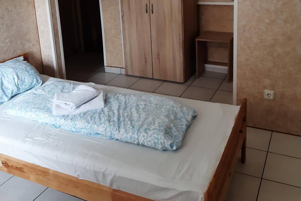 Une chambre à coucher comprenant un lit, une armoire et une petite étagère.