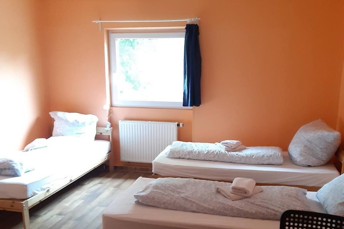 Une chambre de dortoir avec deux lits simples, un bureau et une chaise.