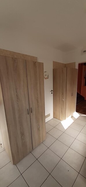 A room with two wooden wardrobes and tiled flooring. - 2-Rent Group Hostel Apartments EVE74 (Munich)