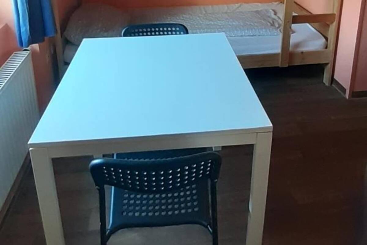 Un lit superposé avec une table et des chaises dans une pièce aux murs orange.