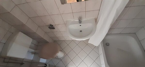 Un baño con lavamanos, inodoro y bañera.
