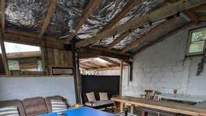 A ping pong table in a room with a sloped ceiling, wooden beams, and a brick wall. - Amazing Country Stay In County Galway, Ireland (Oughterard)