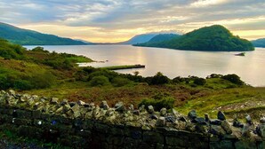 A stone wall with a view of a lake and hills. - Amazing Country Stay In County Galway, Ireland (Oughterard)