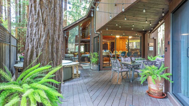 A wooden deck with outdoor seating, surrounded by large trees and potted plants. - Tri-Level MCM Masterpiece, Redwoods, Golf & Spa (Monte Rio)