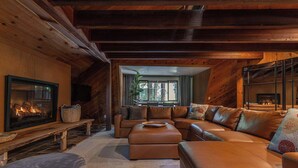A cozy living room with a fireplace, leather sofas, and a stone fireplace surround. - Tri-Level MCM Masterpiece, Redwoods, Golf & Spa (Monte Rio)