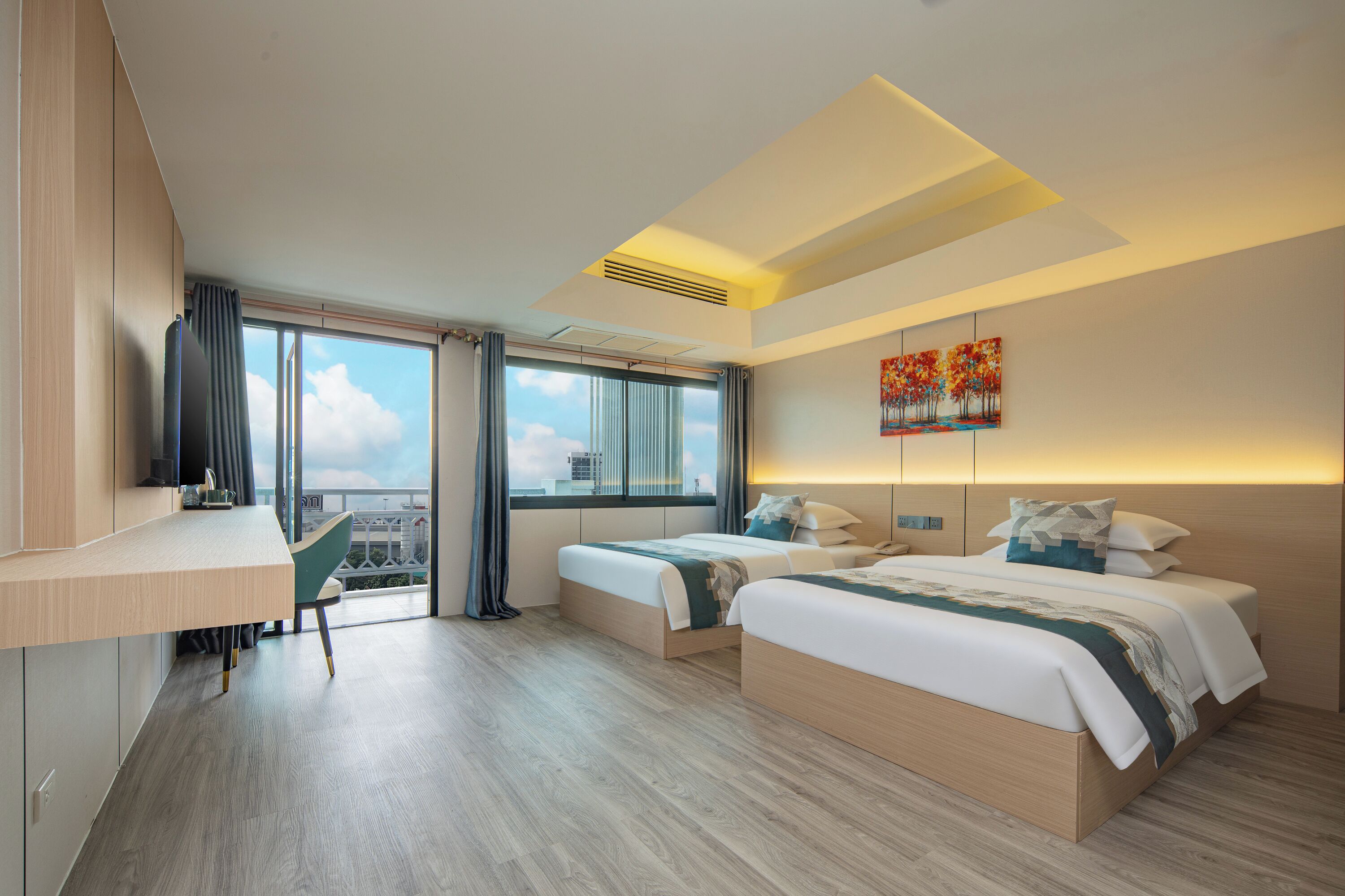 Une chambre d’hôtel moderne avec deux lits, un bureau et une grande fenêtre donnant sur la ville.