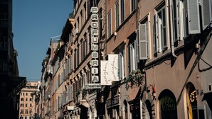 A row of historic buildings with signage for a hotel and a restaurant. - The Rubens Spagna (Rome)