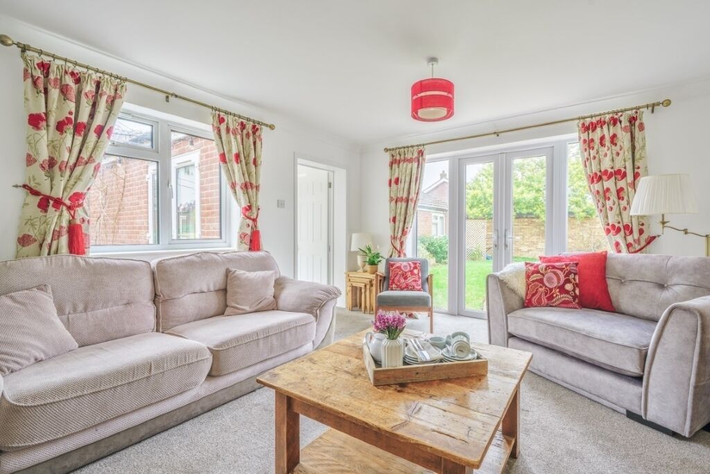 A living room with two sofas, a coffee table, and a window with curtains.
