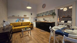 A compact living space with a sofa, dining table, and kitchen area.