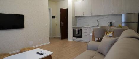 A modern living room with a sofa, a coffee table, and a TV mounted on the wall.