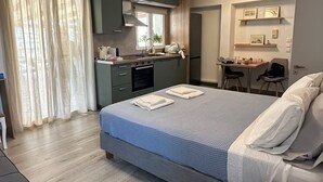A modern hotel room with a large bed, a desk, a kitchenette, and a seating area. - ROOFTOP IN PSYRRI- 360 Athens View (Athina)
