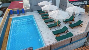 A swimming pool with lounge chairs and umbrellas. - Vila Naço Ksamil (Ksamil)