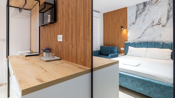 A modern room with a wooden reception desk, a bed with a blue headboard, and a marble wall. - Vila Naço Ksamil (Ksamil)