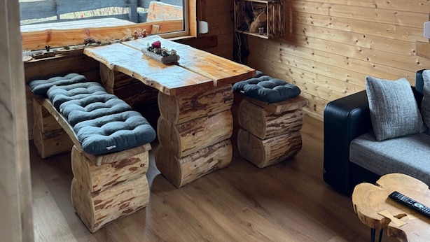 A rustic cabin interior with a wooden table, benches, and a sofa. - Idyllic House in the Harz Mountains (Harzgerode)