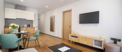 Una sala de estar moderna con un sofá, una mesa de centro y un televisor montado en la pared.
