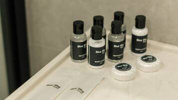 A bathroom counter with several bottles of Blue Sky body lotion and a few empty containers.