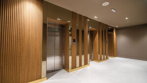 A modern elevator with wooden paneling and a digital display. - Blue Sky Apart-hotel (Batumi)