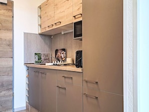 A modern kitchen with wooden cabinets, a built-in coffee machine, and a sign that reads "Fresh Food". - Lovely apartment for 3 people with WIFI, A/C, TV and balcony (Strobl)