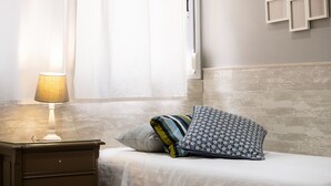 A neatly made bed with pillows, a bedside lamp, and a nightstand. - Maravilloso Duplex en el Corazón de SC (Santa Cruz de Tenerife)