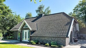 Een twee verdiepingen tellend huis met een schuin dak, een veranda en een gevel van baksteen.