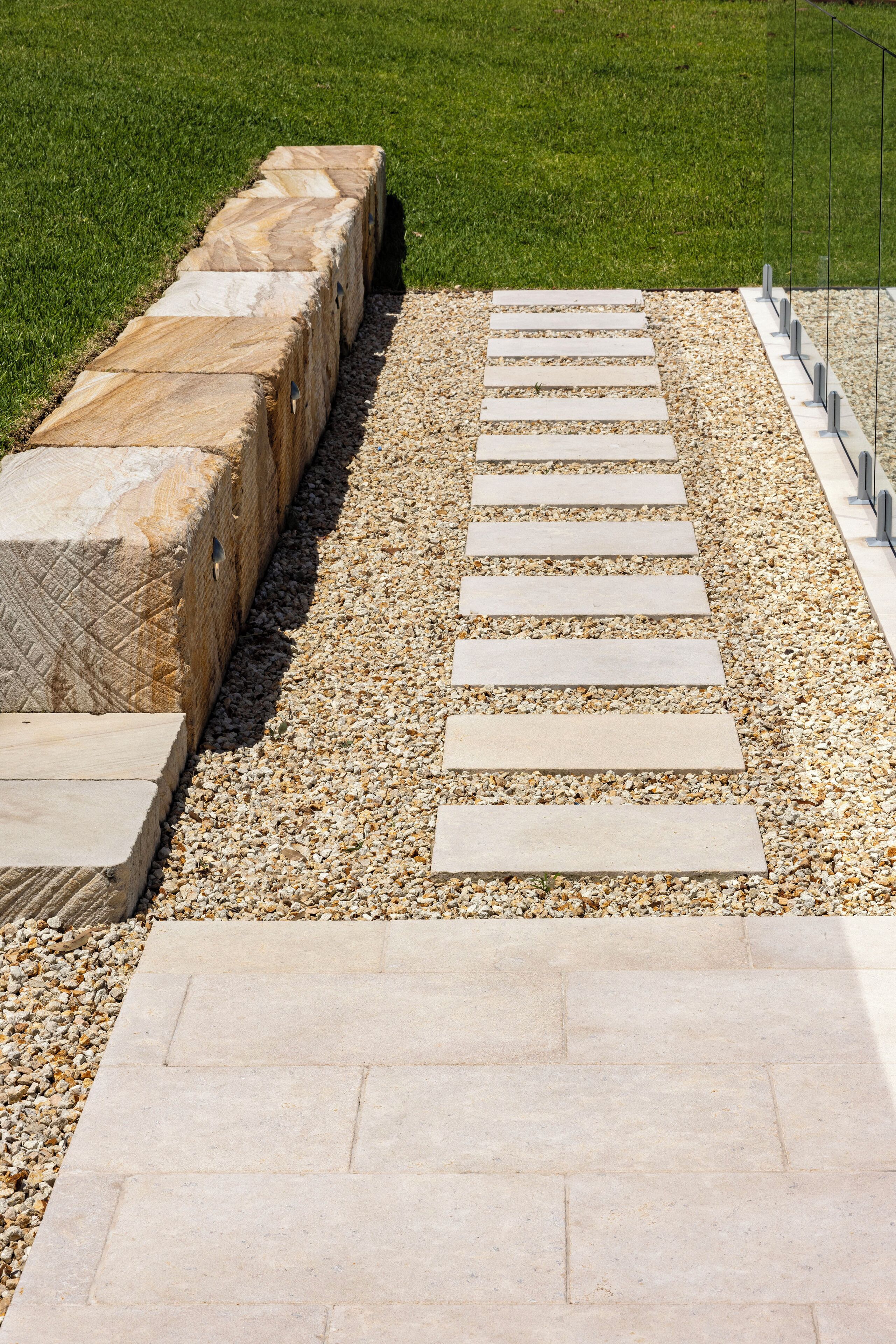 A pathway with stone steps leading to a grassy area.
